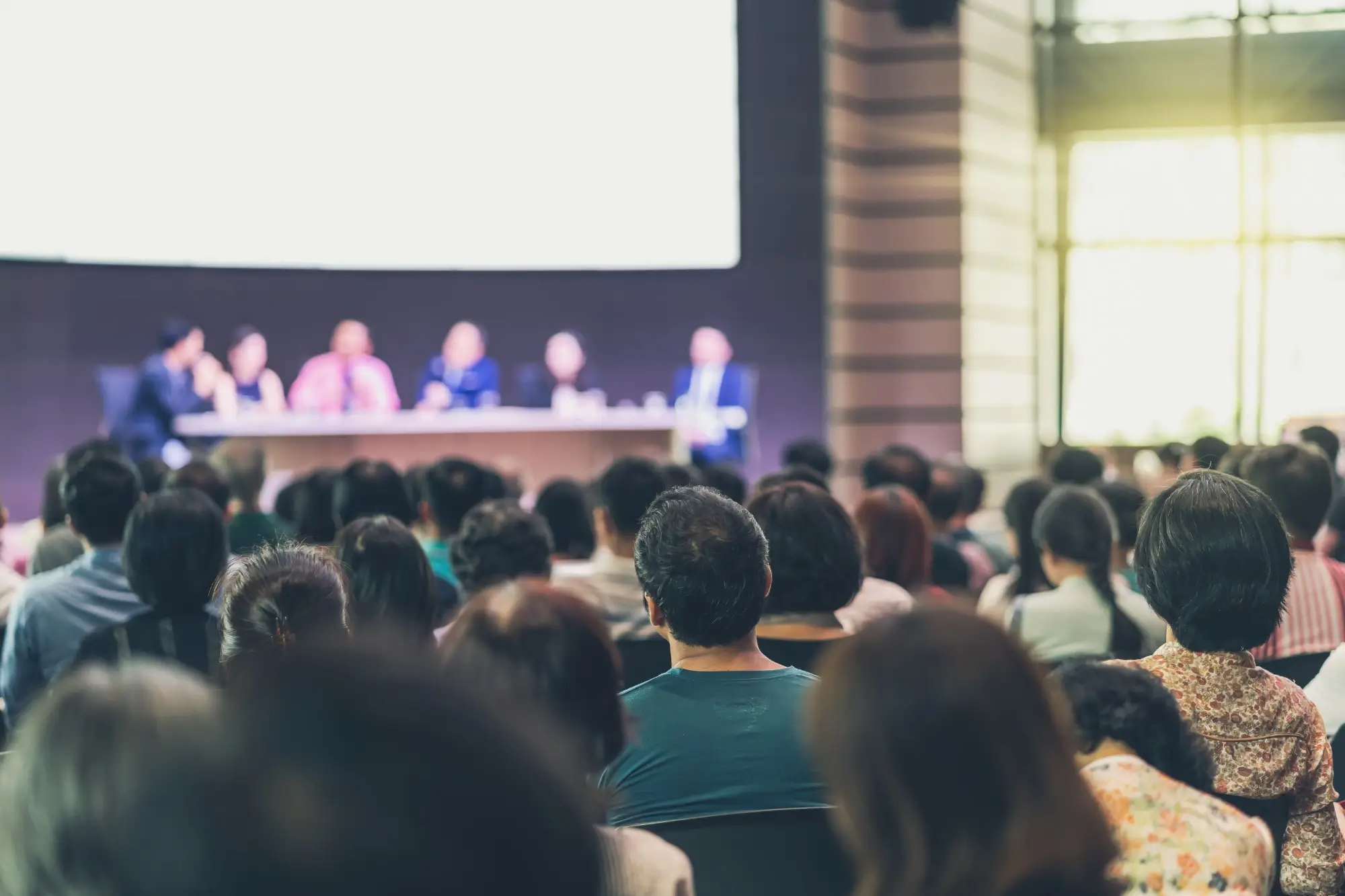 persone che pongono domande in una sala conferenze