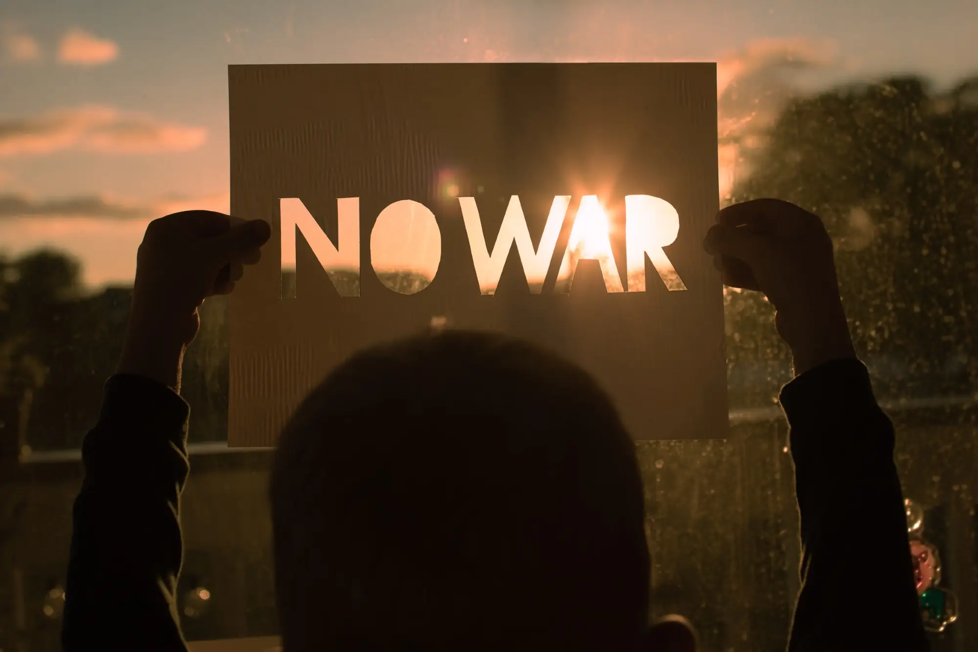 Ragazzo tiene in mano cartello con scritto No War